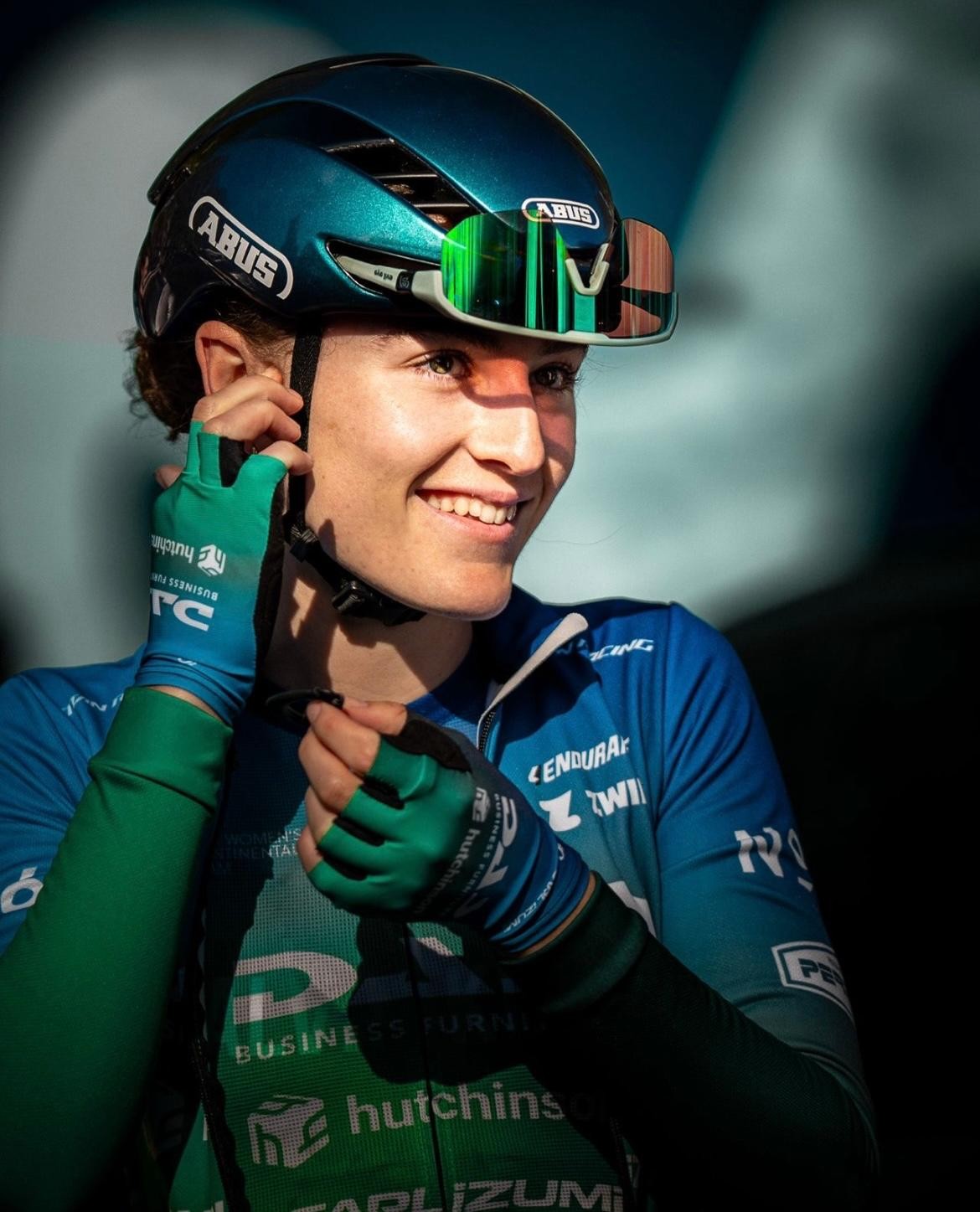 Ellie Parry smiling in her cycling kit and helmet